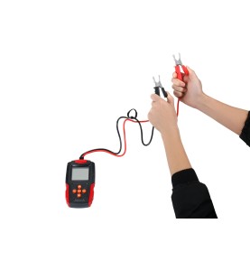 Person hält Batterietester KD5673 mit angeschlossenen Klemmen